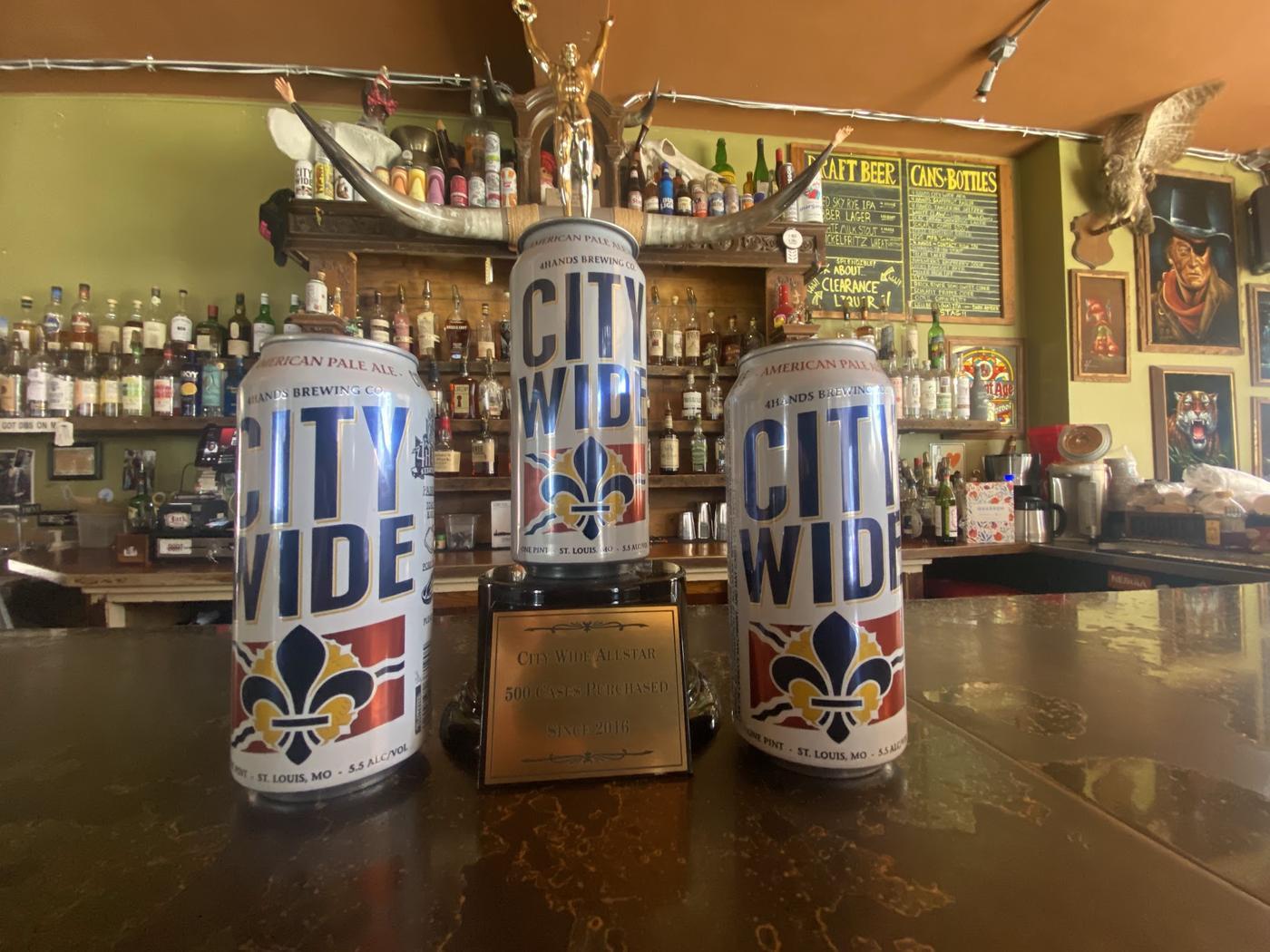 City Wide cans on the bar top beside the bar's City Wide Allstar trophy